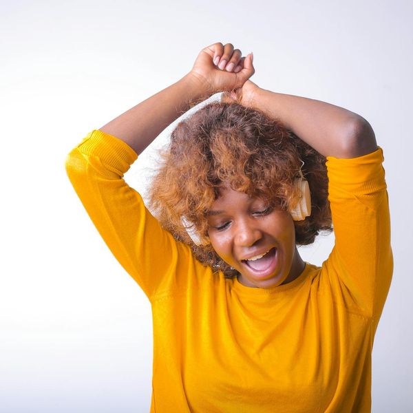 Woman smiling during a gentle stretch, feeling vibrant and energetic.